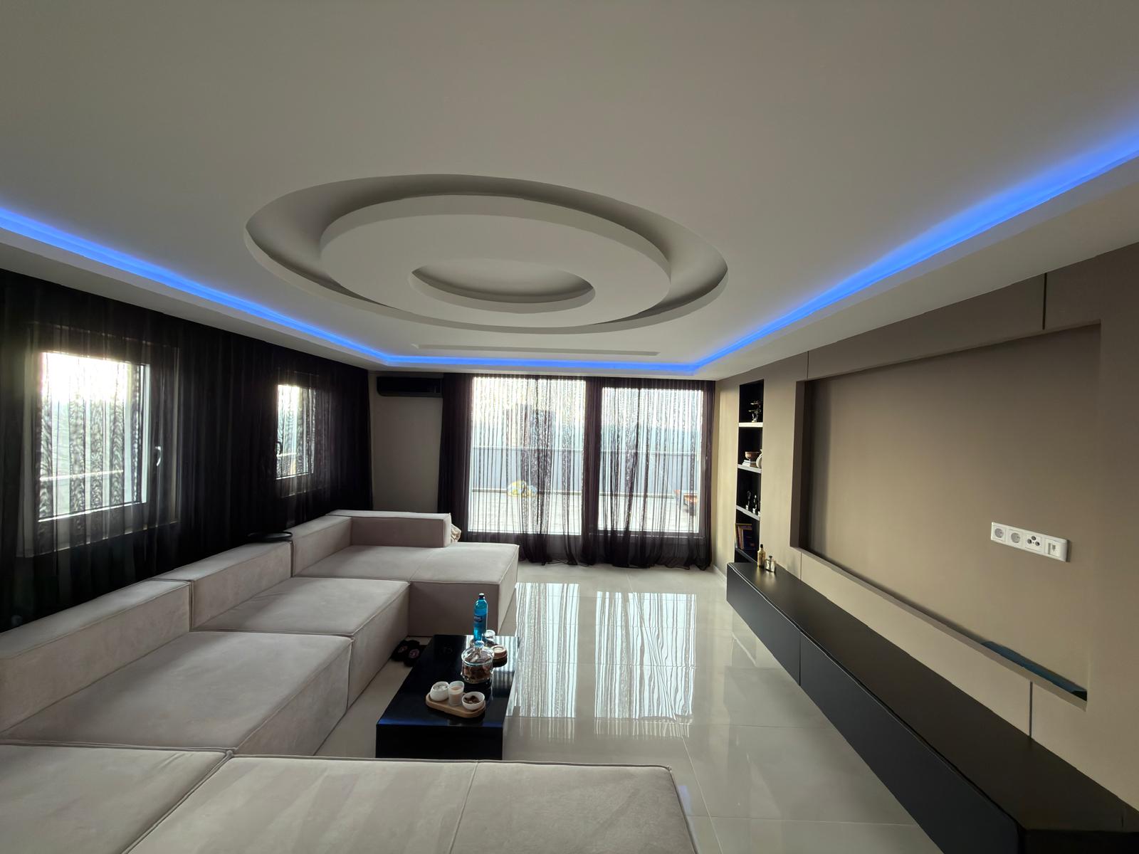 Wohnbereich mit Hebeschiebetür, Großformat-Fliesen 60×120, abgehängter Decke und Zugang zur Terrasse